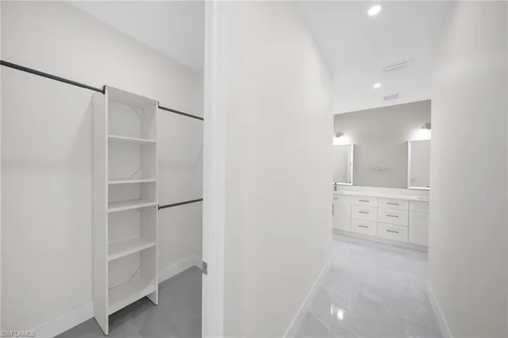Walk in closet with marble finish floor and visible vents