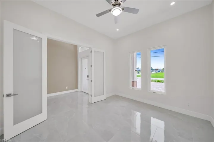 Empty room with a ceiling fan, recessed lighting, marble finish floor, and baseboards