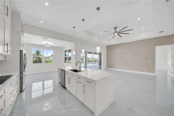 Kitchen with stainless steel appliances, a sink, visible vents, marble finish floor, and a raised ceiling