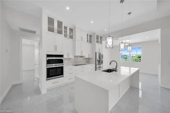 Kitchen featuring marble finish floor, stainless steel appliances, a sink, and visible vents