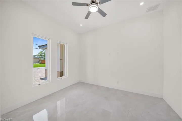 Empty room featuring a ceiling fan, recessed lighting, visible vents, and baseboards