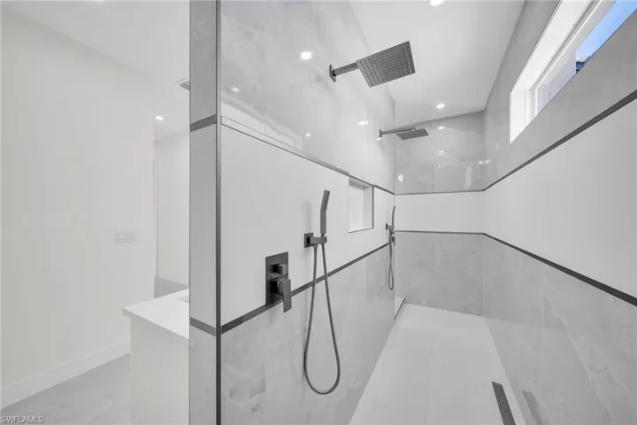 Details featuring recessed lighting, a marble finish shower, and baseboards