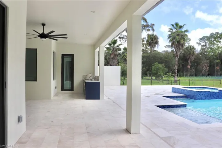View of patio / terrace with ceiling fan, a pool with connected hot tub, and exterior kitchen