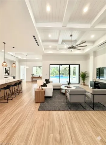 Living room with recessed lighting, healthy amount of natural light, light wood finished floors, a ceiling fan, and a wood ceiling with exposed beams