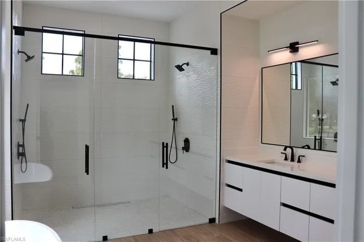 Bathroom with a shower stall, vanity, and light wood-style floors