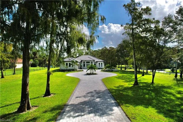 View of property's community featuring decorative driveway and a yard