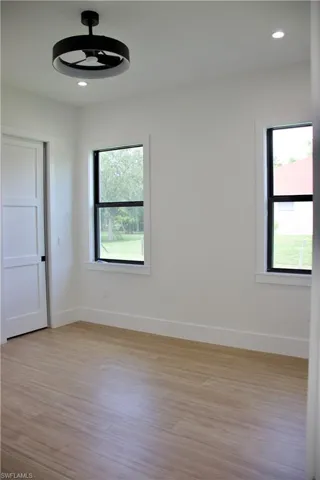 Empty room with light wood-style flooring and recessed lighting