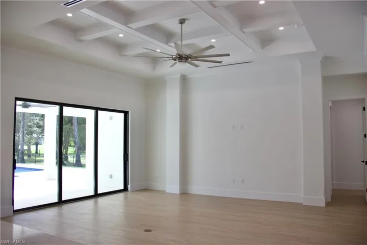 Empty room featuring light wood finished floors, beam ceiling, a ceiling fan, recessed lighting, and coffered ceiling