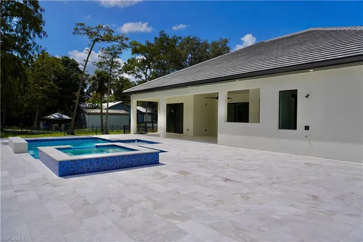 View of pool with a patio area and a pool with connected hot tub