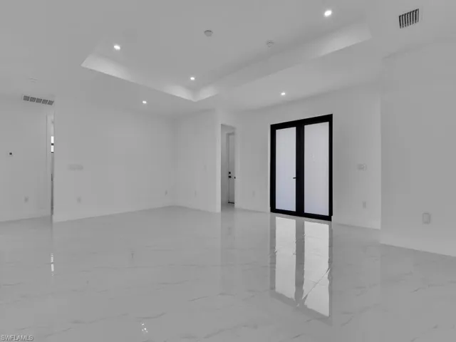 Tiled spare room featuring a tray ceiling