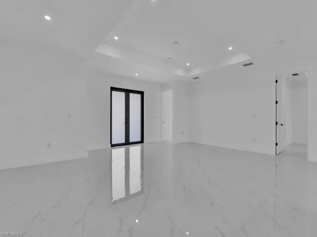 Tiled empty room with a tray ceiling