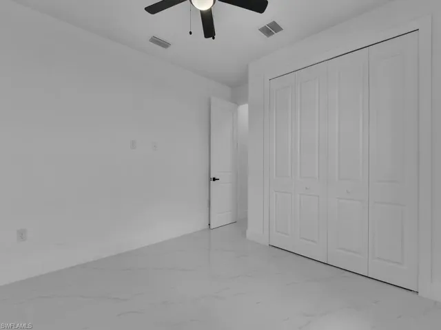 Unfurnished bedroom with a closet, ceiling fan, and light tile patterned floors