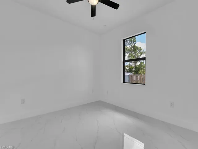 Spare room featuring ceiling fan and tile patterned floors