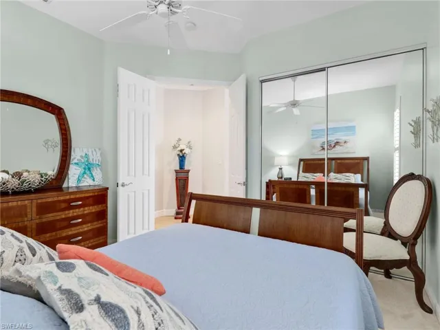 Bedroom featuring a closet, a ceiling fan, and light colored carpet
