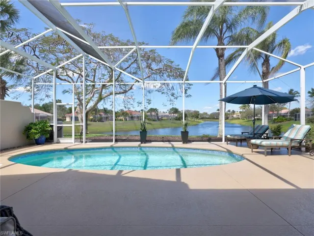Outdoor pool featuring a sunroom, a water view, glass enclosure, and a patio