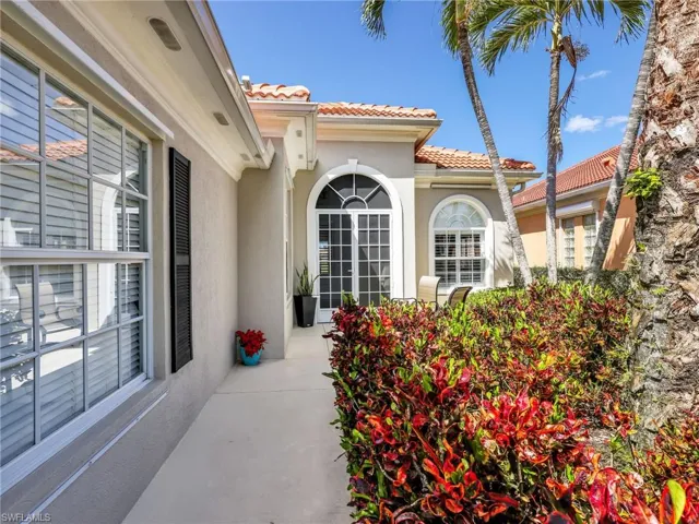 Doorway to property with a tile roof and stucco siding