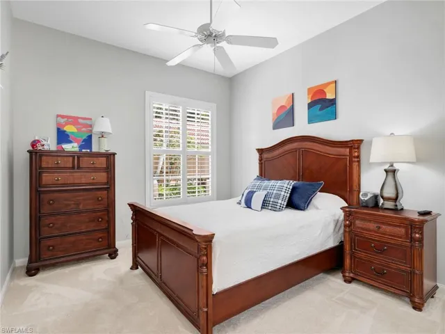 Bedroom with ceiling fan and light colored carpet