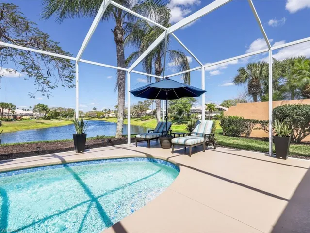 Outdoor pool with a sunroom, a lanai, and a water view
