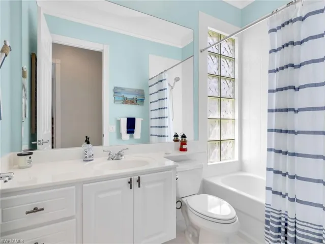 Full bath featuring vanity and shower / bathtub combination with curtain