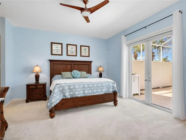 Bedroom with light colored carpet, french doors, access to outside, and a ceiling fan