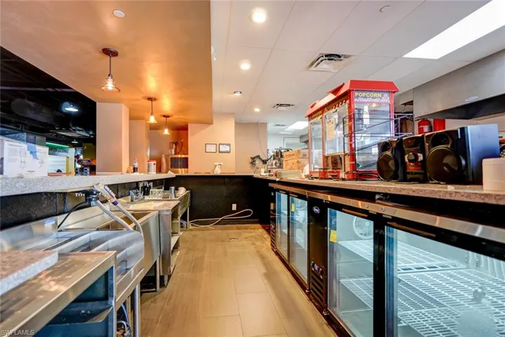 Bar featuring decorative light fixtures, a paneled ceiling, and beverage cooler