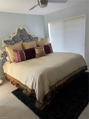 Bedroom with ceiling fan and a textured ceiling