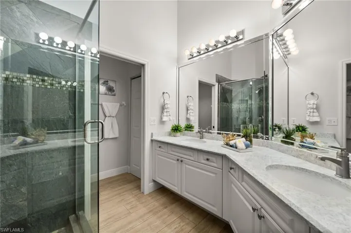 Updated Master bathroom with quartz countertop, dual sinks & glass-enclosed shower.