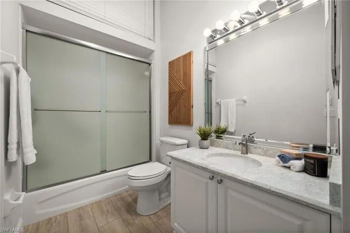 Guest bathroom with matching quartz countertop & high ceiling.