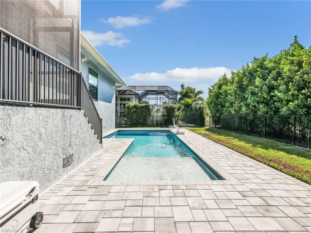View of pool featuring a patio, a fenced backyard, and a lanai