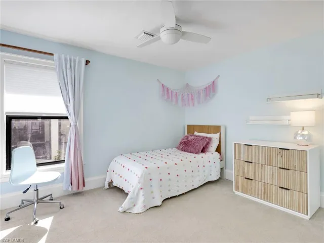 Carpeted bedroom featuring a ceiling fan and baseboards