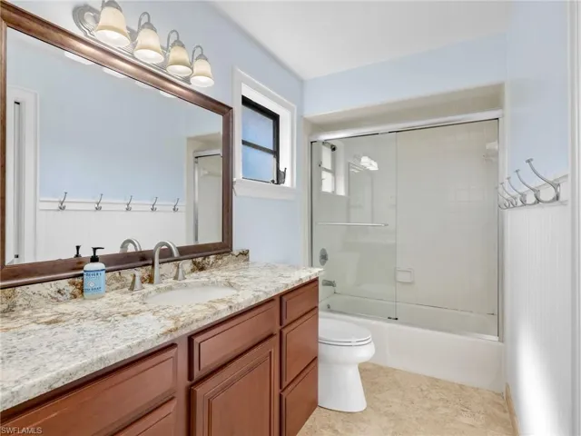 Bathroom featuring vanity and enclosed tub / shower combo