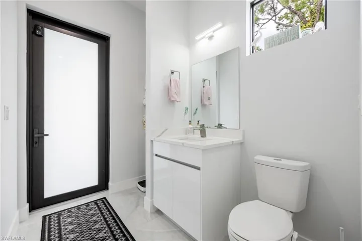 Half bath featuring vanity and baseboards