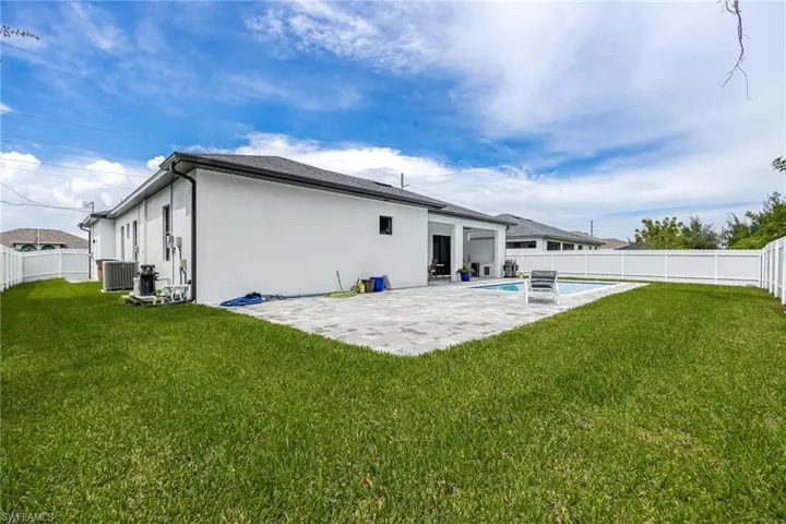 Rear view of property featuring a fenced backyard, a patio, and stucco siding