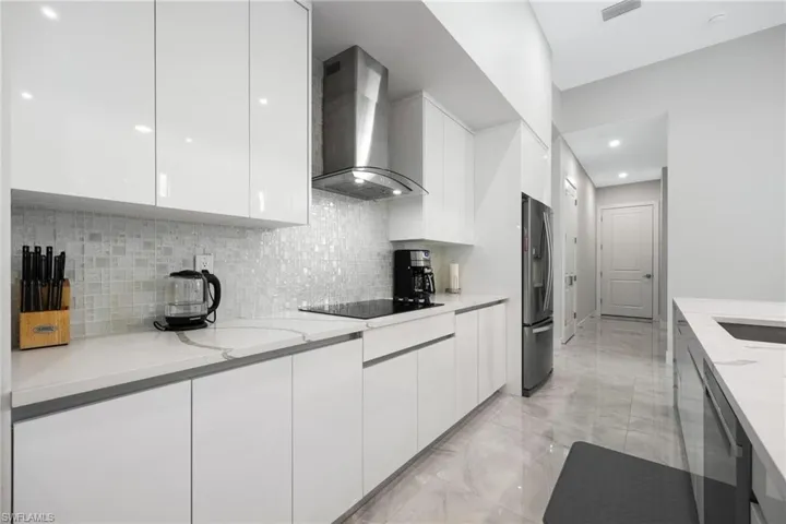 Kitchen with modern cabinets, white cabinets, and recessed lighting
