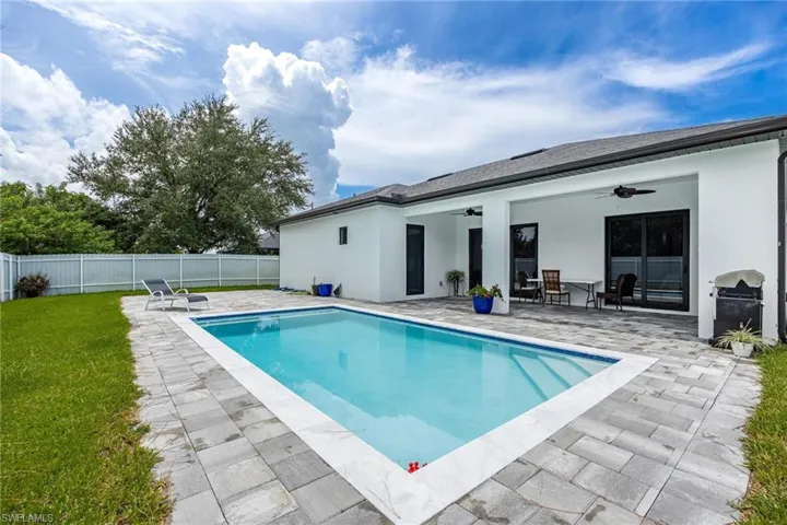 View of pool featuring a ceiling fan, a patio, a fenced backyard, and a grill
