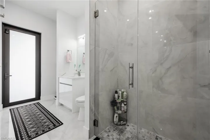 Full bath featuring vanity and a marble finish shower
