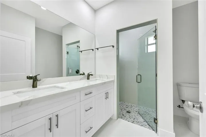 Bathroom with a shower stall and double vanity
