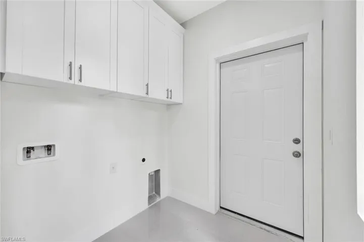 Laundry room featuring light tile patterned floors, hookup for a washing machine, hookup for an electric dryer, and cabinet space