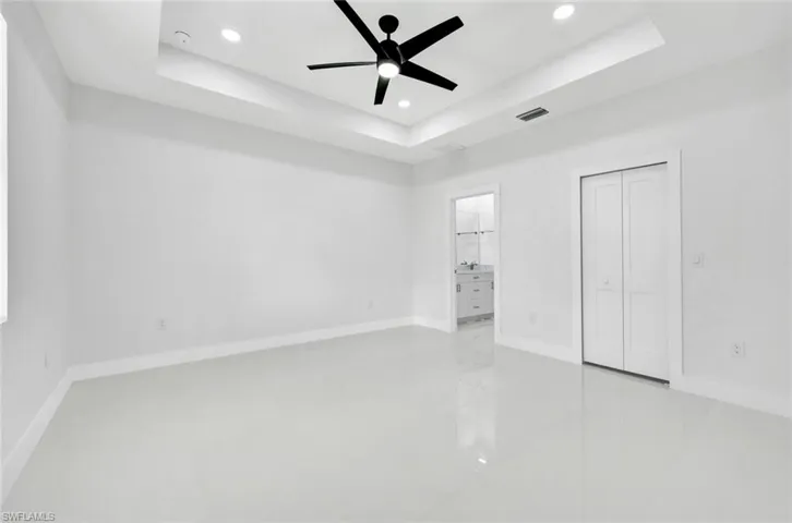 Unfurnished bedroom with recessed lighting, a closet, ceiling fan, and a raised ceiling