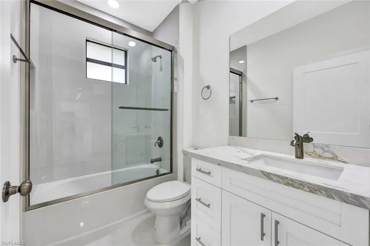Full bathroom featuring enclosed tub / shower combo, vanity, and recessed lighting