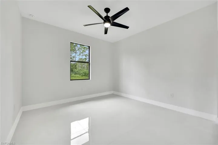 Spare room with baseboards and a ceiling fan