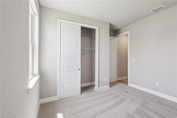Unfurnished bedroom featuring carpet flooring, a closet, and baseboards