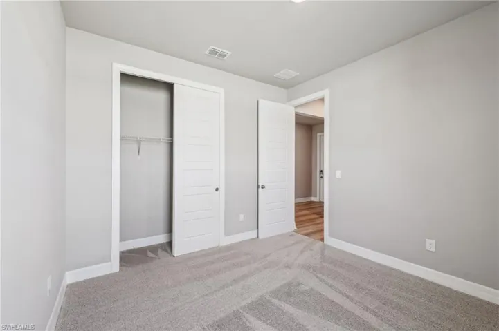 Unfurnished bedroom with carpet floors, a closet, and baseboards