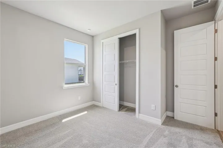 Unfurnished bedroom featuring carpet flooring, baseboards, and a closet
