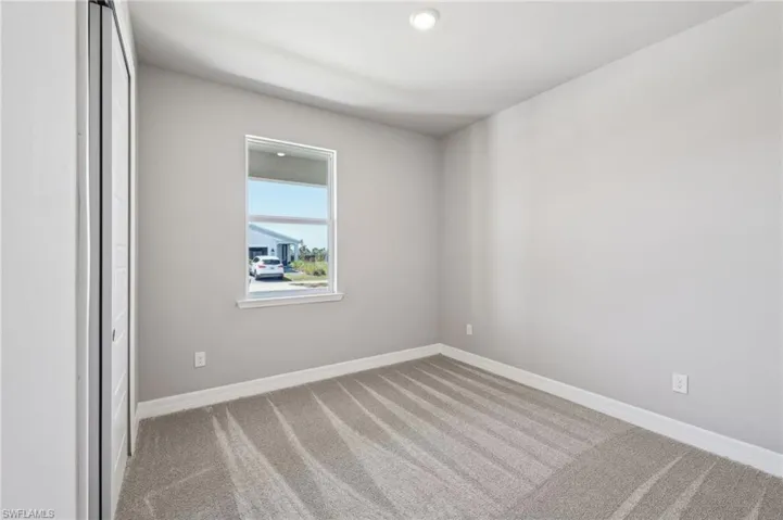 Empty room with carpet floors and baseboards