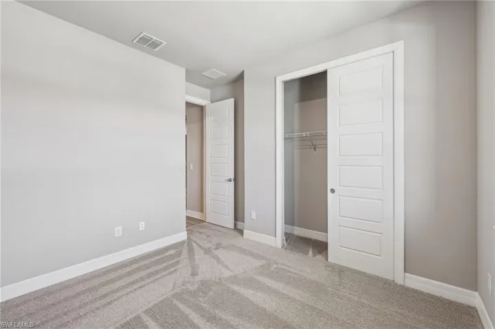 Unfurnished bedroom featuring carpet flooring, baseboards, and a closet