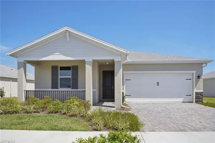 Ranch-style house with decorative driveway, a porch, an attached garage, and stucco siding