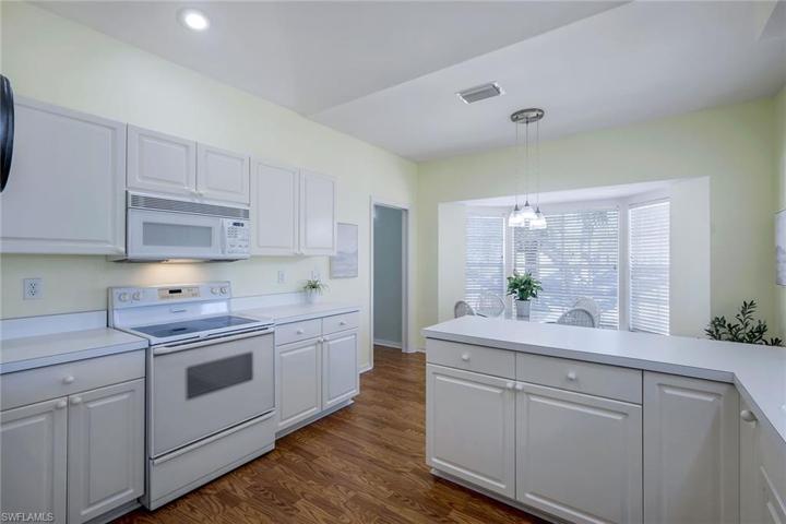 Crisp white kitchen with adjacent bay window dining room