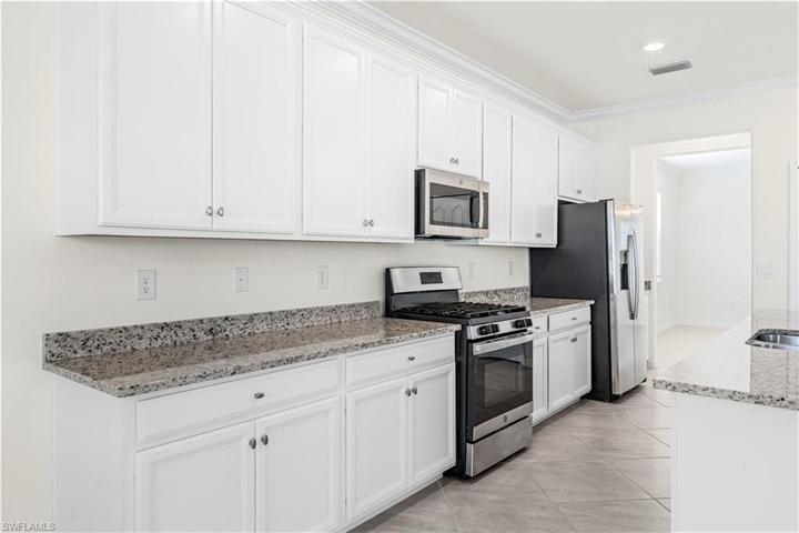 Granite tops and gorgeous white cabintry, tile floors through kitchen and all gathering areas