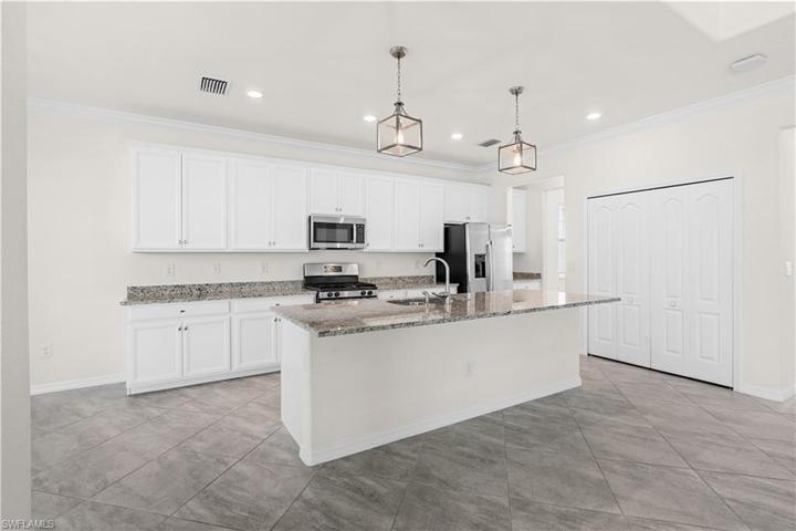 Gas stove, large island with lots of seating and tons of kitchen cabinets.